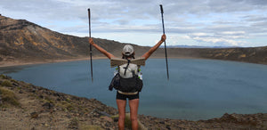 A person standing on top of a mountain with two poles in their hands.