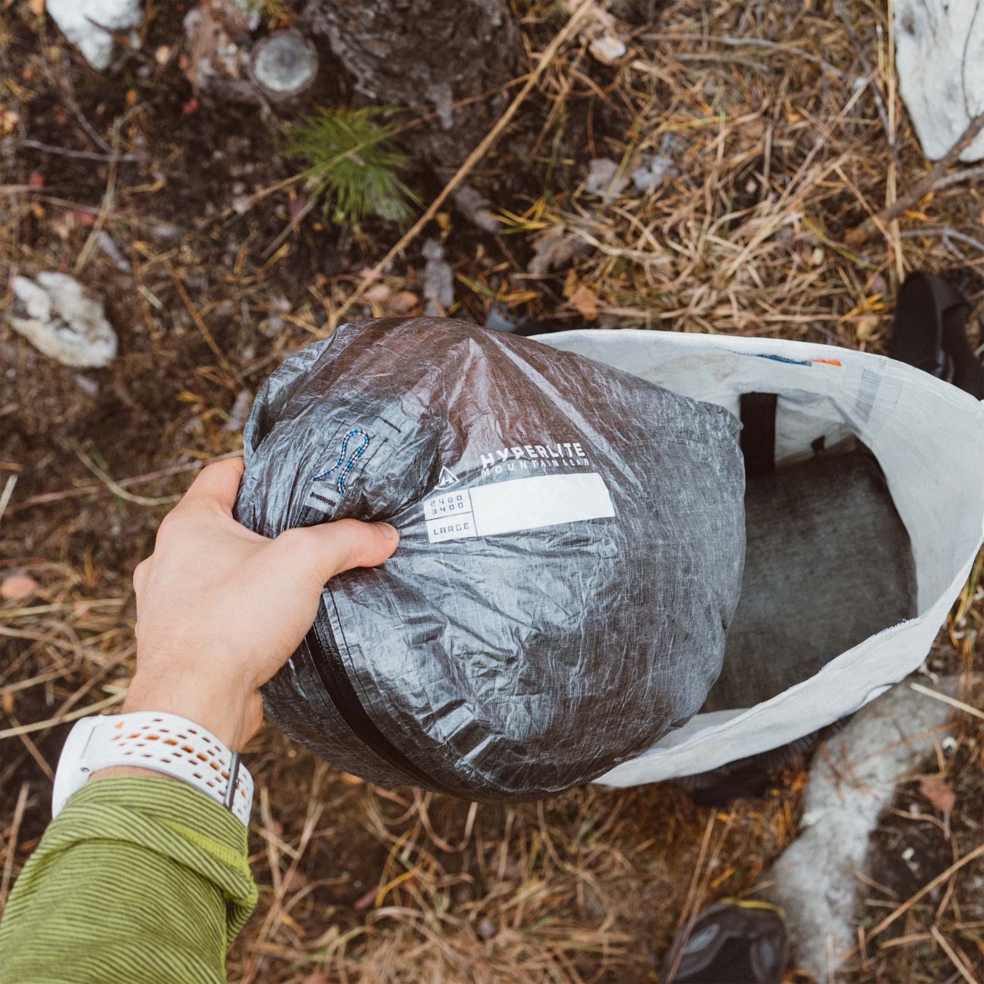 A person holding a bag on the ground.